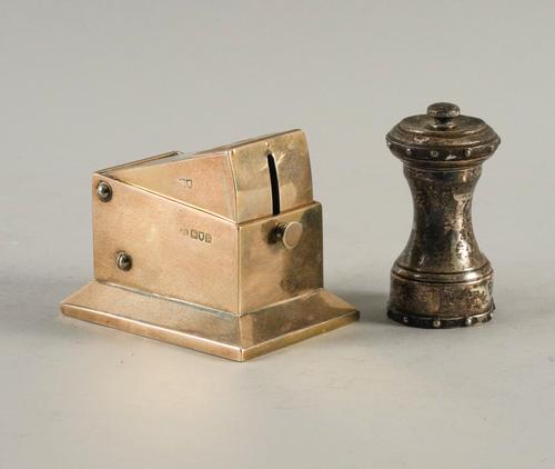 A SILVER TABLE CIGAR CUTTER AND A SILVER MOUNTED PEPPER MILL (2)