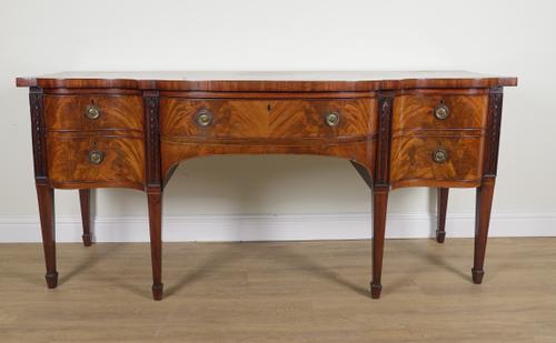 A LARGE GEORGE III MAHOGANY SERPENTINE FRONTED THREE DRAWER SIDEBOARD