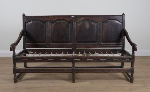 AN 18TH CENTURY OAK FOUR PANEL BACK OPEN ARM SETTLE