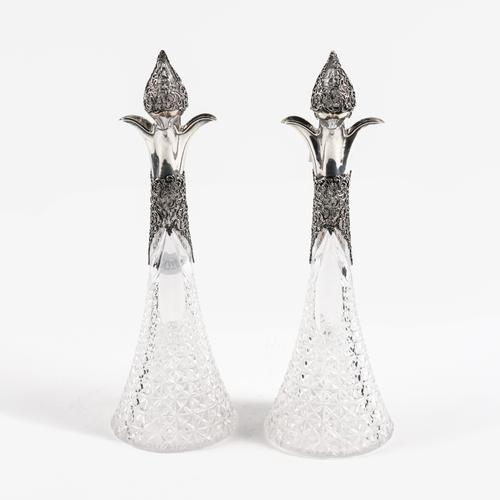 A PAIR OF LATE VICTORIAN SILVER MOUNTED FACETED GLASS DECANTERS AND STOPPERS (2)