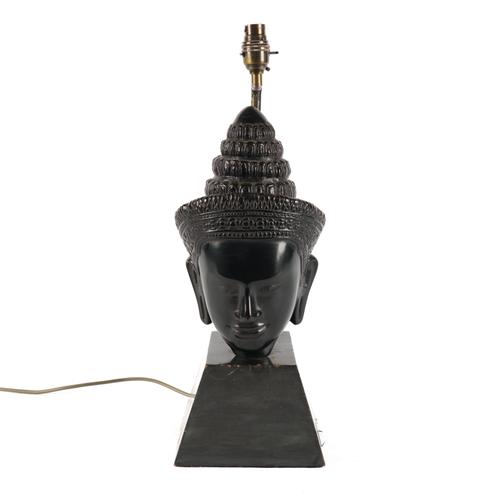 A PATINATED BRONZE HEAD OF BUDDHA MOUNTED TO FORM A TABLE LAMP