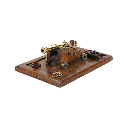 A BRASS MOUNTED OAK MODEL OF A CANNON