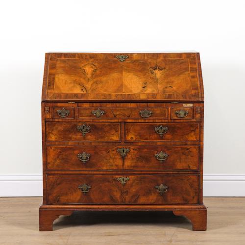 A GEORGE I FIGURED FEATHER BANDED WALNUT BUREAU