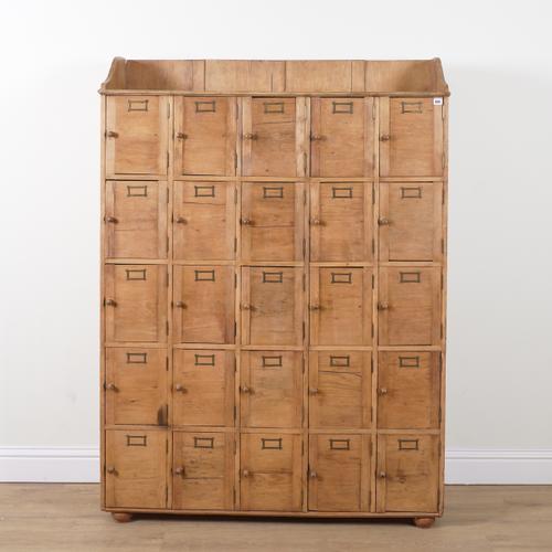 AN EARLY 20TH CENTURY PINE TWENTY-FIVE DOOR LOCKER CABINET