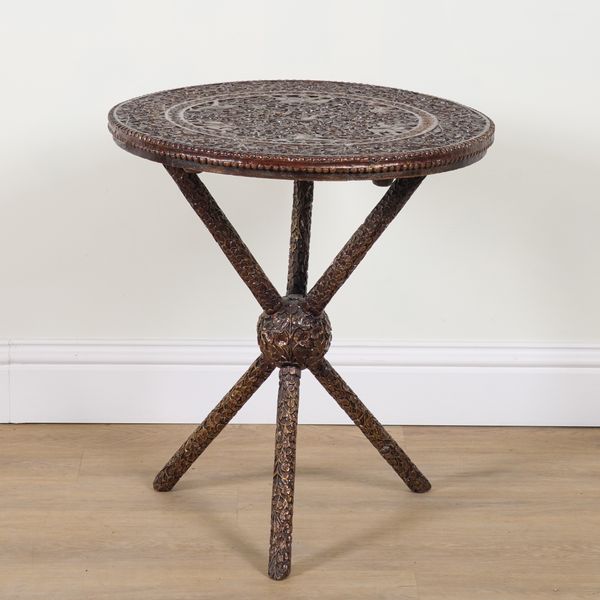 AN EARLY 20TH CENTURY BURMESE EXTENSIVELY CARVED TEAK CIRCULAR OCCASIONAL TABLE