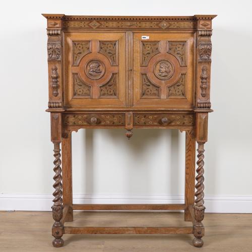 A 19TH CENTURY CARVED AND INLAID OAK CABINET