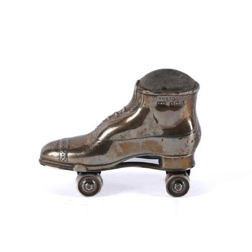 A SILVER PIN CUSHION MODELLED AS A ROLLER SKATE