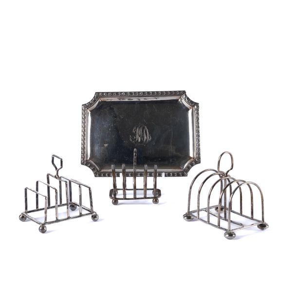 A CONTINENTAL CARD TRAY AND THREE SILVER FIVE BAR TOASTRACKS (4)