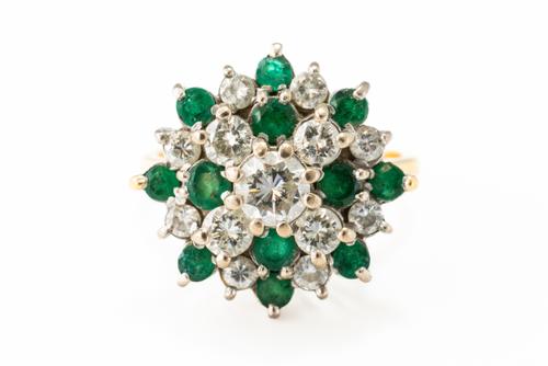 AN EMERALD AND DIAMOND CLUSTER RING