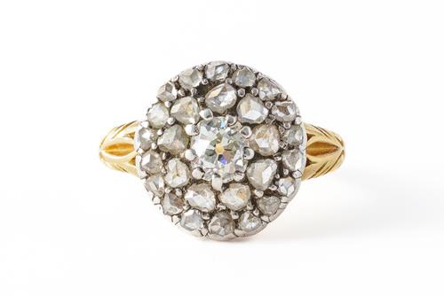 A GOLD AND SILVER SET DIAMOND CLUSTER RING