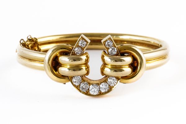 A GOLD AND DIAMOND SET OVAL HINGED BANGLE