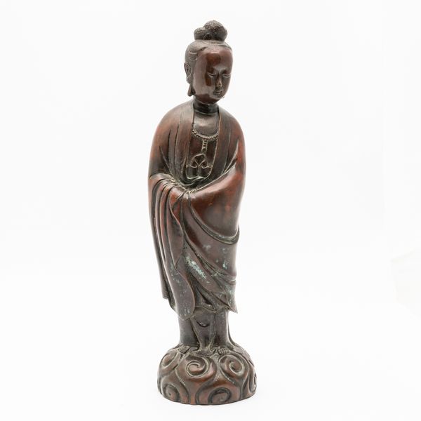 A CHINESE SILVER-INLAID PATINATED BRONZE FIGURE OF GUANYIN