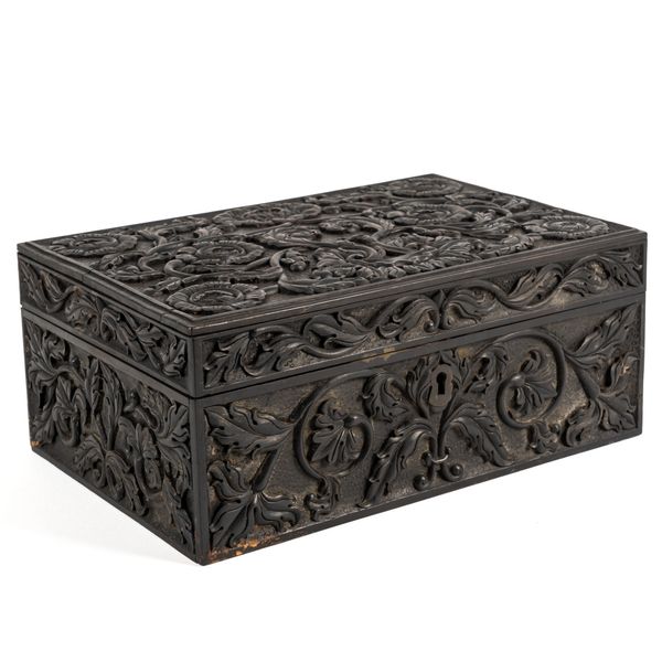 A CARVED EBONISED BOX