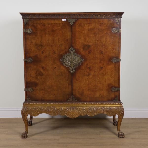 A GEORGE II STYLE FIGURED WALNUT TWO DOOR CABINET ON GILTWOOD STAND