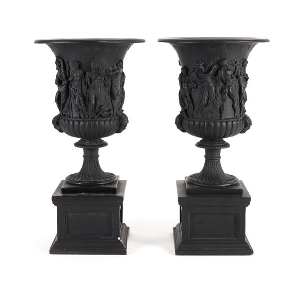 A PAIR OF FAUX BLACK SLATE URNS OF CLASSICAL DESIGN