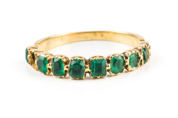 A GOLD AND EMERALD HALF HOOP RING