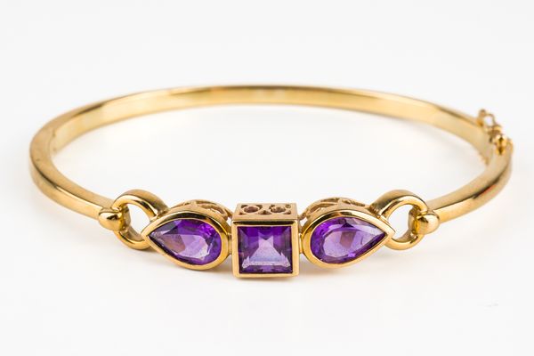 A GOLD AND AMETHYST SET BANGLE