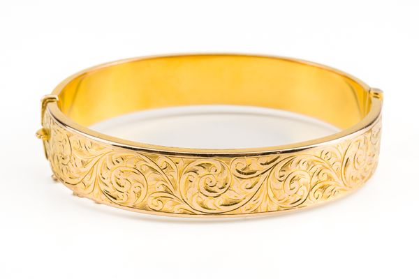 A 9CT GOLD OVAL HINGED BANGLE