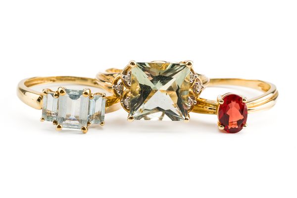 A 9CT GOLD AND AQUAMARINE THREE STONE RING AND TWO FURTHER 9CT GOLD AND GEM SET RINGS (3)