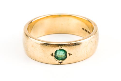 A 9CT GOLD AND EMERALD BAND RING