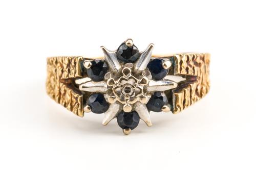 AN 18CT GOLD, SAPPHIRE AND DIAMOND SEVEN STONE CLUSTER RING
