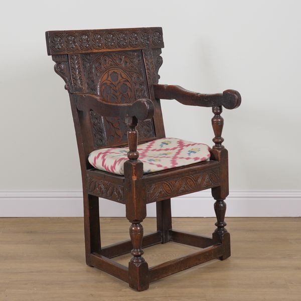 A 17TH CENTURY CARVED OAK WAINSCOT OPEN ARMCHAIR