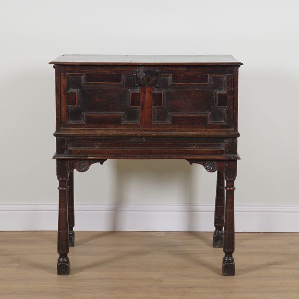 A 17TH CENTURY OAK LIFT TOP BOX ON STAND