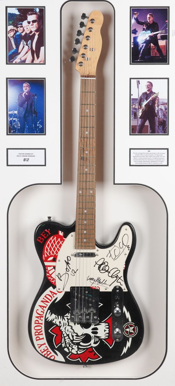 A GUITAR SIGNED BY U2 MOUNTED IN A DISPLAY CASE