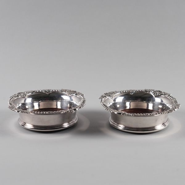 A PAIR OF SILVER MOUNTED BOTTLE COASTERS (2)