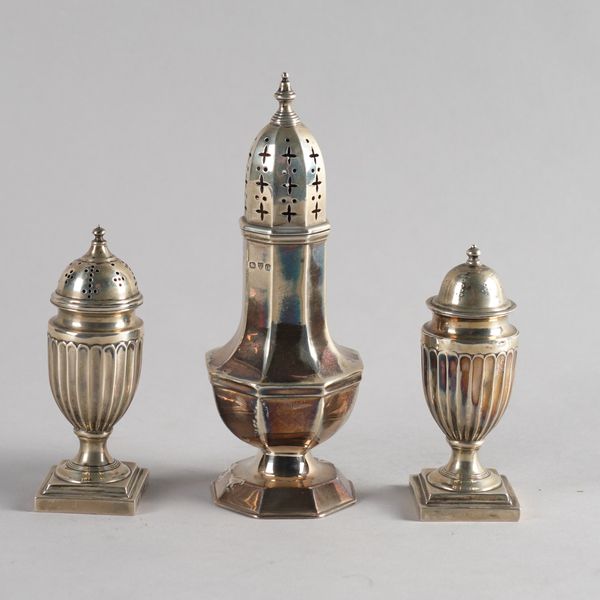 A SILVER OCTAGONAL SUGAR CASTER AND TWO SILVER PEPPERETTES (3)