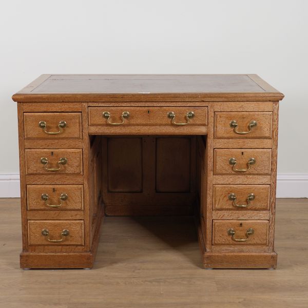 AN EARLY 20TH CENTURY LIMED OAK NINE DRAWER KNEEHOLE WRITING DESK