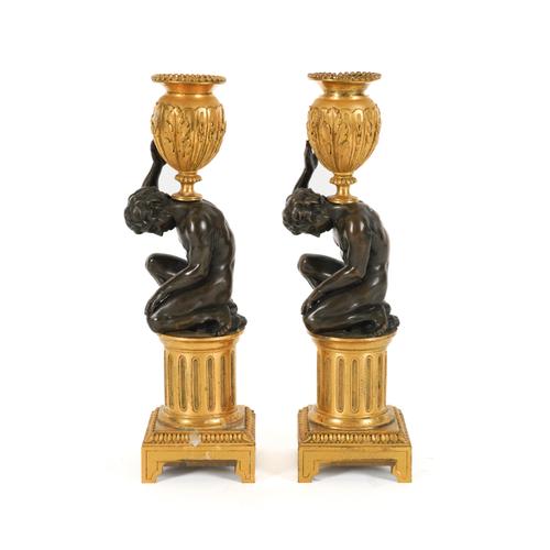 A PAIR OF FRENCH LOUIS XVI STYLE GILT AND PATINATED BRONZE ‘ATLAS’ FIGURAL CANDLESTICKS (2)