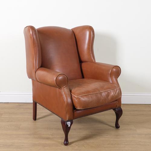 LAURA ASHLEY; A GEORGE II STYLE TAN LEATHER UPHOLSTERED WING BACK ARMCHAIR