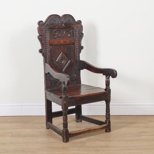 A 17TH CENTURY CARVED AND INLAID OAK WAINSCOT OPEN ARMCHAIR