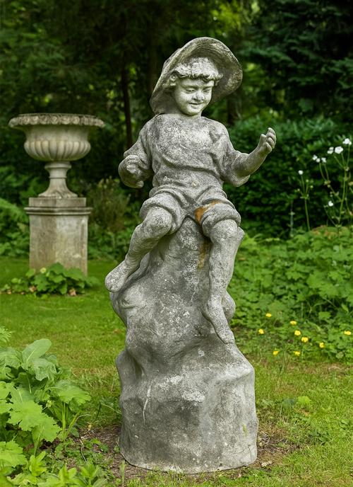 A RECONSTITUTED STONE FIGURE OF A SEATED FISHERBOY