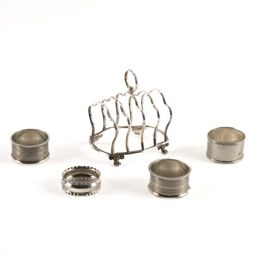 A LATE VICTORIAN SILVER TOASTRACK AND FOUR SILVER NAPKIN RINGS (5)