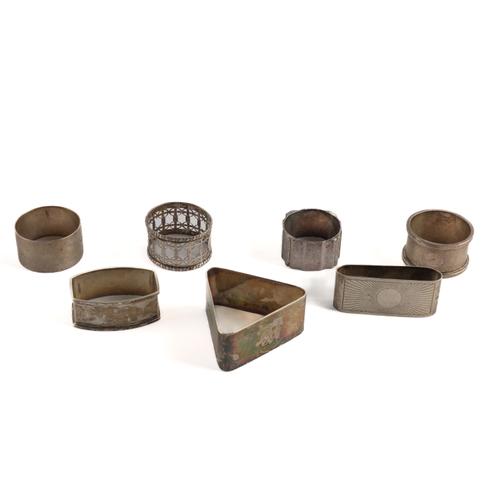 A SILVER TRIANGULAR NAPKIN RING AND SIX FURTHER SILVER NAPKIN RINGS (7)