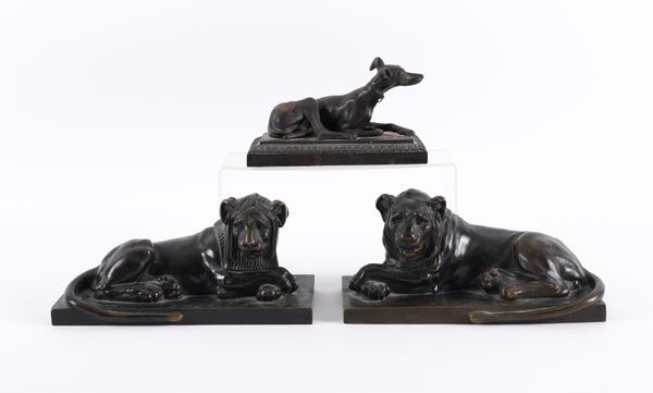 A PAIR OF REGENCY STYLE PATINATED BRONZE RECUMBENT LIONS AND A PAPER WEIGHT MODELLED AS A WHIPPET (3)