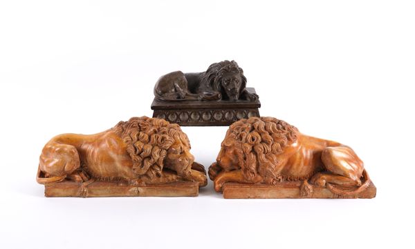 AFTER ANTONIO CANOVA: A PAIR OF TERRACOTTA PAINTED PLASTER RECUMBENT LIONS (3)