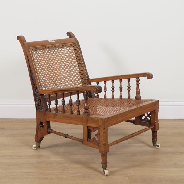 AN ARTS AND CRAFTS WALNUT LOW CANE ARMCHAIR