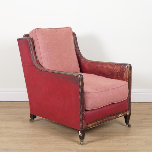 AN EARLY 20TH CENTURY BRASS STUDDED ROUGE LEATHER UPHOLSTERED EASY ARMCHAIR
