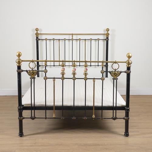 AN EARLY 20TH CENTURY BLACK PAINTED AND BRASS DOUBLE BED