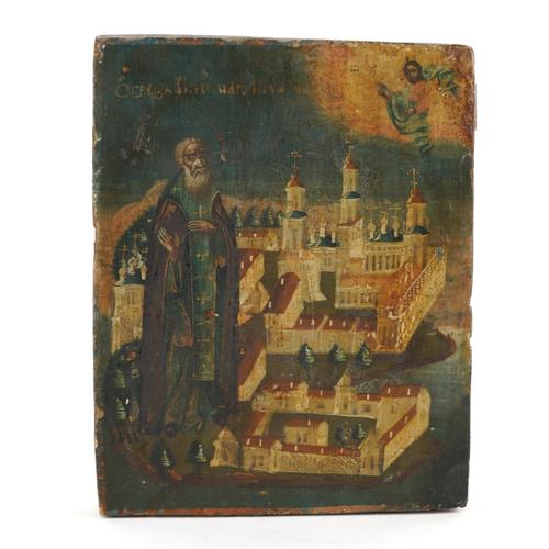 OF RUSSIAN ICON INTEREST: A PAINTED AND GILT-HEIGHTENED PANEL DEPICTING A SAINT BLESSING A WALLED MONASTRY