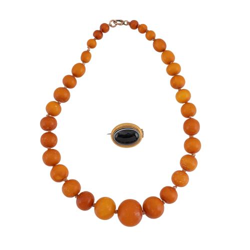 A SINGLE ROW NECKLACE OF AMBER BEADS AND A VICTORIAN AGATE BROOCH (2)