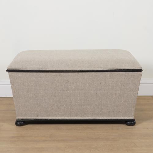 AN EBONISED UPHOLSTERED LIFT TOP OTTOMAN