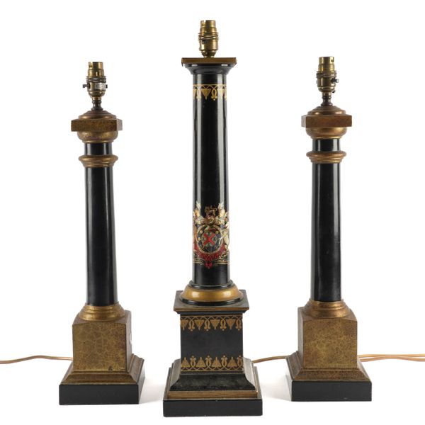 A PARCEL-GILT BLACK TOLE PIENTE TABLE LAMP DECORATED WITH A ROYAL COAT OF ARMS TOGETHER WITH A PAIR OF SIMILAR COLUMN TABLE LAMPS (3)