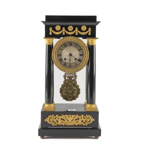 A FRENCH EMPIRE STYLE GILT METAL MOUNTED EBONISED PORTICO CLOCK