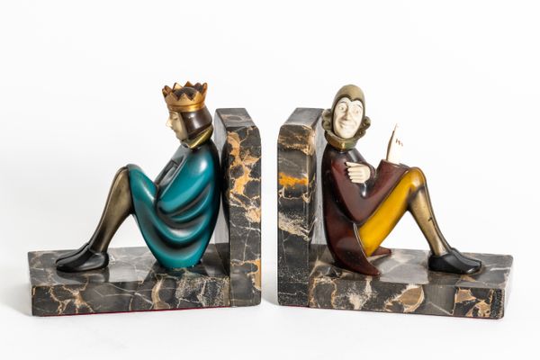 ROLAND PARIS (1894-1945): A PAIR OF COLD-PAINTED BRONZE AND IVORY FIGURAL BOOKENDS OF THE KING AND THE SCHOLAR (2)