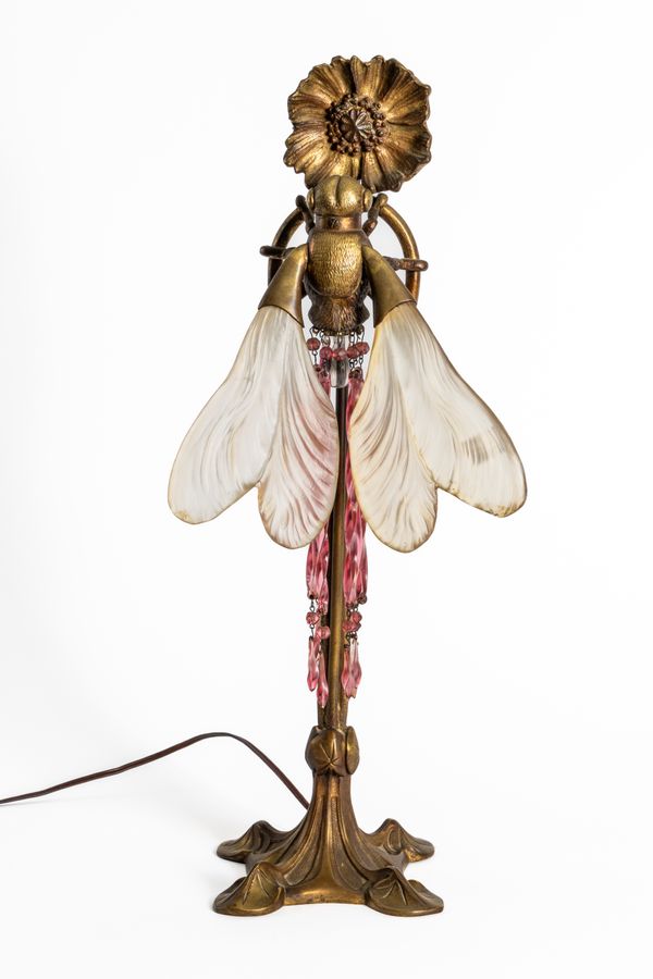 AN ART NOUVEAU GILT-BRASS AND FROSTED GLASS TABLE LAMP IN THE FORM OF A DRAGONFLY AND FLOWER