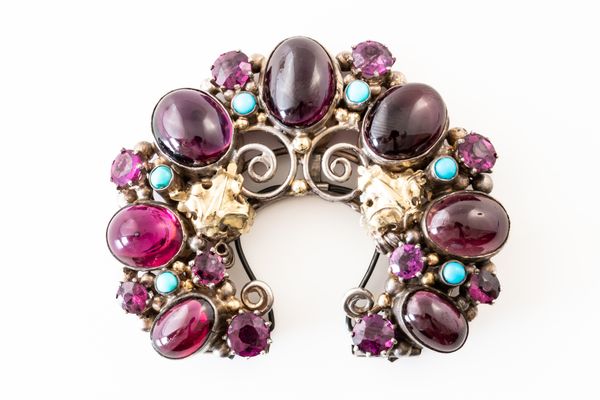 ATTRIBUTED TO DORRIE NOSSITER: A HALF MOON GEMSET CLIP BROOCH